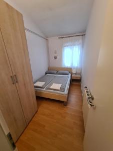 a small bedroom with a bed and a door at Apartma z dvema spalnicama in teraso in Portorož