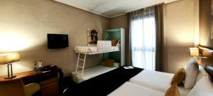 a hotel room with a bed and a shelf with towels at Hotel Puerta de Toledo in Madrid
