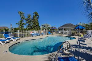 una piscina con sedie e sedie blu e una recinzione di Lazy Willow 102 a Myrtle Beach