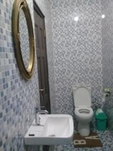 a bathroom with a toilet and a sink and a mirror at Mixtech Vacation Home -MVH in Sunyani
