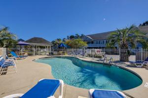 una piscina con sedie blu e recinzione di Lazy Willow 102 a Myrtle Beach