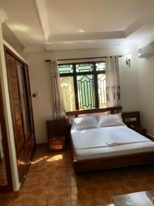 una camera con un grande letto e una finestra di COAST VIEW RESORT a Kigoma