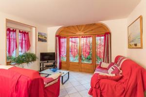 ein Wohnzimmer mit 2 roten Stühlen und einem TV in der Unterkunft Le clair-soleil in Briaucourt