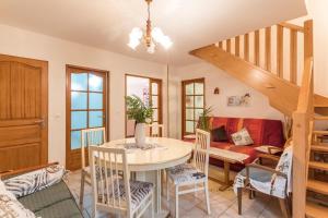 ein Wohnzimmer mit einem Tisch und einem Sofa in der Unterkunft Le clair-soleil in Briaucourt