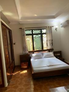 a bedroom with a large bed with a window at COAST VIEW RESORT in Kigoma