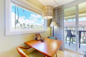 uma sala de jantar com uma mesa e uma janela em Islander on the Beach 315 em Kapaa