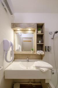 La salle de bains est pourvue d'un lavabo et d'un miroir. dans l'établissement Residence Des Thermes, à Lons-le-Saunier
