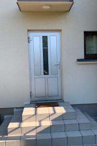een witte deur op een wit gebouw met een raam bij Private room, private bathroom, private entrance in private house in Kaunas