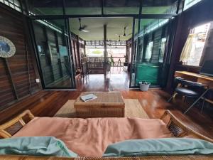 a room with a bed and a table and some windows at Non House Hostel บ้านนอนโฮสเทล in Bangkok