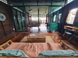 Habitación con cama, mesa y algunas ventanas. en Non House Hostel บ้านนอนโฮสเทล en Bangkok