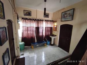 a living room with red curtains and a blue bench at MONALISA HOSTEL in Varanasi