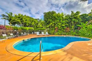 a swimming pool in a resort with chairs and trees at Kapa'a Sands 07 in Kapaa