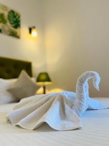 a swan made out of towels on a bed at J Leaf Hotel By Blue Bird in Negombo