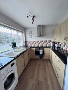 a kitchen with a sink and a washing machine at 3 bed house in Walsall, perfect for contractors & leisure & free parking in Walsall