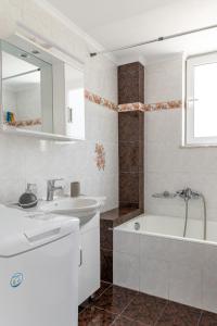 uma casa de banho branca com um lavatório e uma banheira em Pallas em Keratea