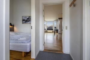 a bedroom with a bed and a door leading to a kitchen at Hotel Icefiord in Ilulissat