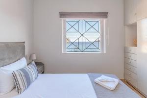 um quarto branco com uma cama e uma janela em Pallas em Keratea