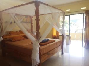 a bedroom with a bed with a canopy at Wisma Leuser Sibayak in Bukit Lawang
