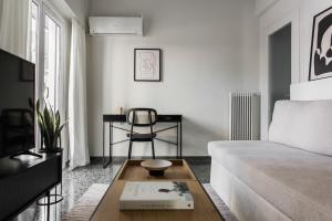 uma sala de estar com um sofá e uma mesa de centro em Glorious 1BR Apartment in Athens by UPSTREET em Atenas