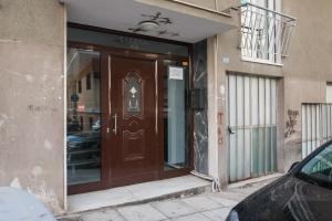uma porta castanha do lado de um edifício em Glorious 1BR Apartment in Athens by UPSTREET em Atenas
