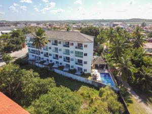 uma vista aérea de um edifício branco com uma piscina em Aquarius Residence em Porto de Galinhas