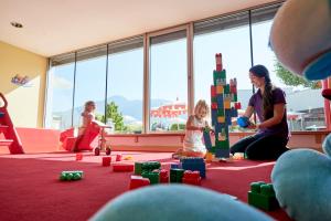 a woman and a child playing with blocks in a room at Familotel Amiamo in Zell am See