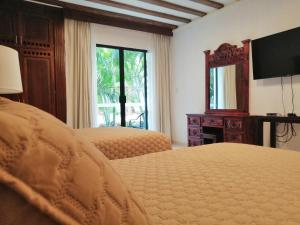 a bedroom with two beds and a large window at Casa San Roque Valladolid in Valladolid