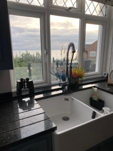 a kitchen with a large white sink in front of a window at The Patch in Hill Head