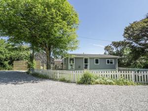 a house with a white picket fence at Orchard Lodge in Pwllheli