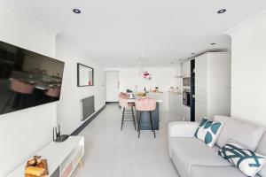 7 Bayview, Vernon Court في توركواي: غرفة معيشة بيضاء مع أريكة بيضاء ومطبخ