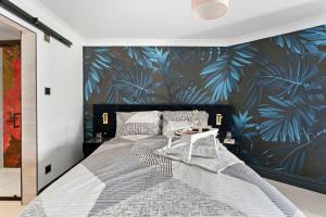 una camera da letto con un grande letto e carta da parati tropicale di 7 Bayview, Vernon Court a Torquay
