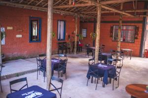 a group of tables and chairs in a brick building at Pousada Recanto da Lua in Caparaó Velho