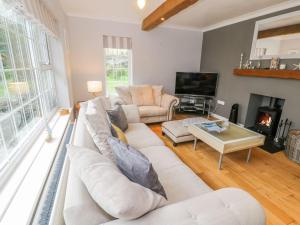 a living room with a white couch and a fireplace at The Orchard in Pwllheli