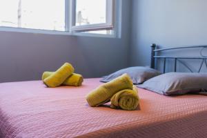 a bed with yellow towels and pillows on it at Modiano Studio ΙΙ By Socrates Junior Houses in Thessaloniki