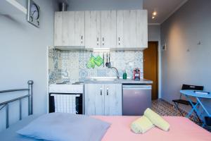 a small kitchen with white cabinets and a sink at Modiano Studio ΙΙ By Socrates Junior Houses in Thessaloniki