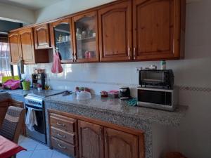 a kitchen with wooden cabinets and a microwave oven at APPARTEMENT ZENITH in Casablanca