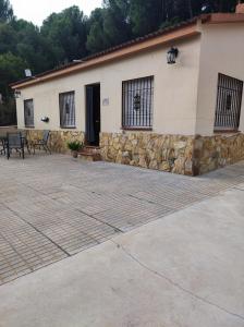 une maison avec un mur en pierre et une terrasse dans l'établissement EL RINCON DE ANGELA, à Cordoue