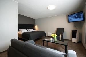een hotelkamer met een bed en een woonkamer bij Koto Hotel Pihtipudas in Pihtipudas