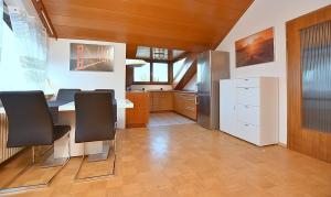 a kitchen with a table and a refrigerator at BB City Appartements in Böblingen