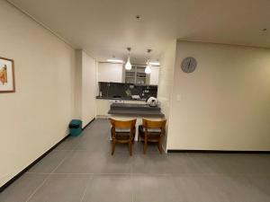 a kitchen with a table and chairs in a room at Hotel With in Busan