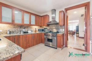 a kitchen with wooden cabinets and a stove top oven at Be relaxed at this 2BR apt at Casa De Campo in Buena Vista