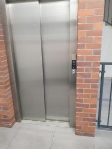 metalowe drzwi windy w ceglanej ścianie w obiekcie Apartament Gliwice Górnych Walów w mieście Gliwice +12 zdjęć