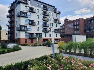 wysoki biały budynek z balkonami na dziedzińcu w obiekcie Apartament Gliwice Górnych Walów w mieście Gliwice