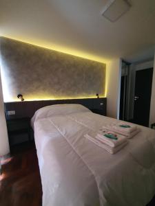 a bedroom with a white bed with towels on it at LOCADOR Nueva Cordoba 3C in Cordoba +4 photos