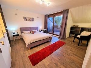 Schlafzimmer mit einem Bett und einem roten Teppich in der Unterkunft Ferme de la Gibussière in Présilly