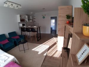 ein Wohnzimmer mit einem Sofa und einem Tisch in einem Zimmer in der Unterkunft Apartments Manna Palic in Palić