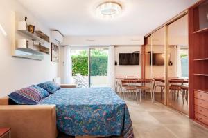 1 Schlafzimmer mit einem Bett und einem Esszimmer in der Unterkunft SUPERBE STUDIO AVEC TERRASSE EN FRONT DE MER in Menton