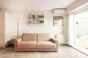 ein Wohnzimmer mit einem Sofa und einem Fenster in der Unterkunft SUPERBE STUDIO AVEC TERRASSE EN FRONT DE MER in Menton