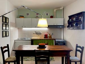 une cuisine avec une table, des chaises et une lampe dans l'établissement Dagli Olivari - Casa Teo, à Gromo