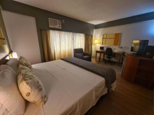 ein Hotelzimmer mit einem großen Bett und einem Schreibtisch in der Unterkunft Flat Borges Lagoa Ibirapuera c/ garagem UH508 in São Paulo